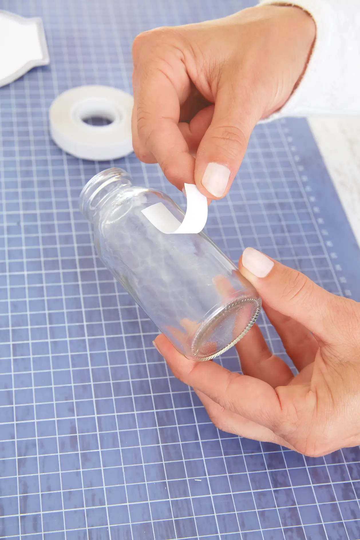 Εφαρμόστε μια λωρίδα αυτοκόλλητης ταινίας διπλής όψης tesa® στα γυάλινα μπουκάλια. Αφαιρέστε την προστατευτική μεμβράνη.