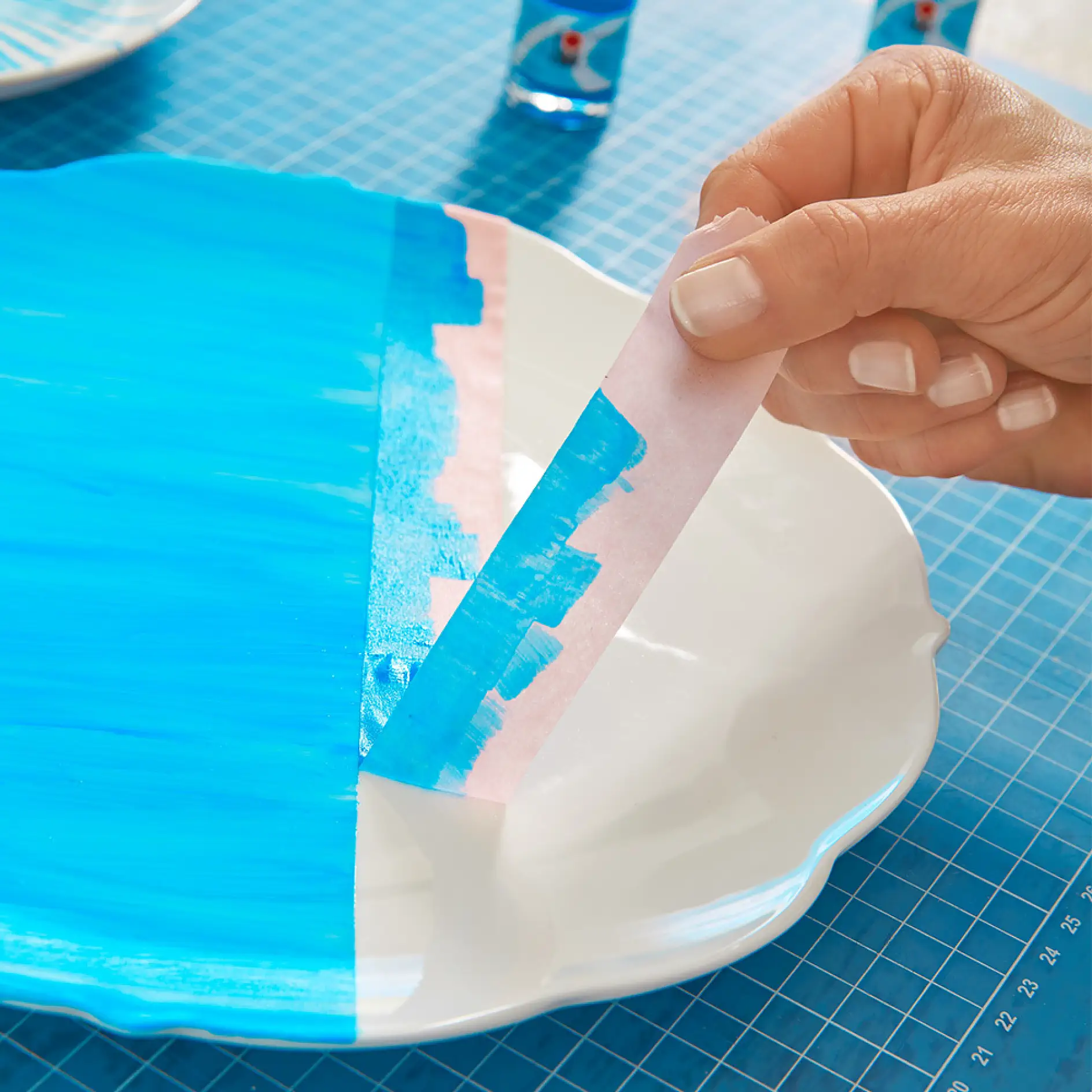 Χρησιμοποιήστε ταινία μασκαρίσματος για να φτιάξετε μια σύνθεση από DIY διακοσμητικά πιάτα τοίχου.