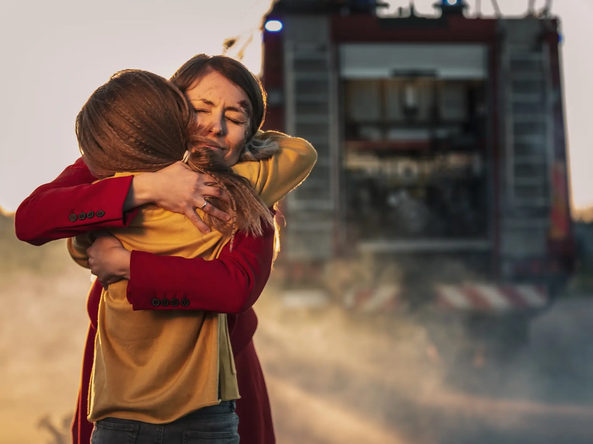 Car Crash Traffic Accident: Injured Young Girl Reunites with Her Loving Mother. In the Background Fire engine and Courageous Paramedics and Firemen Save Lives