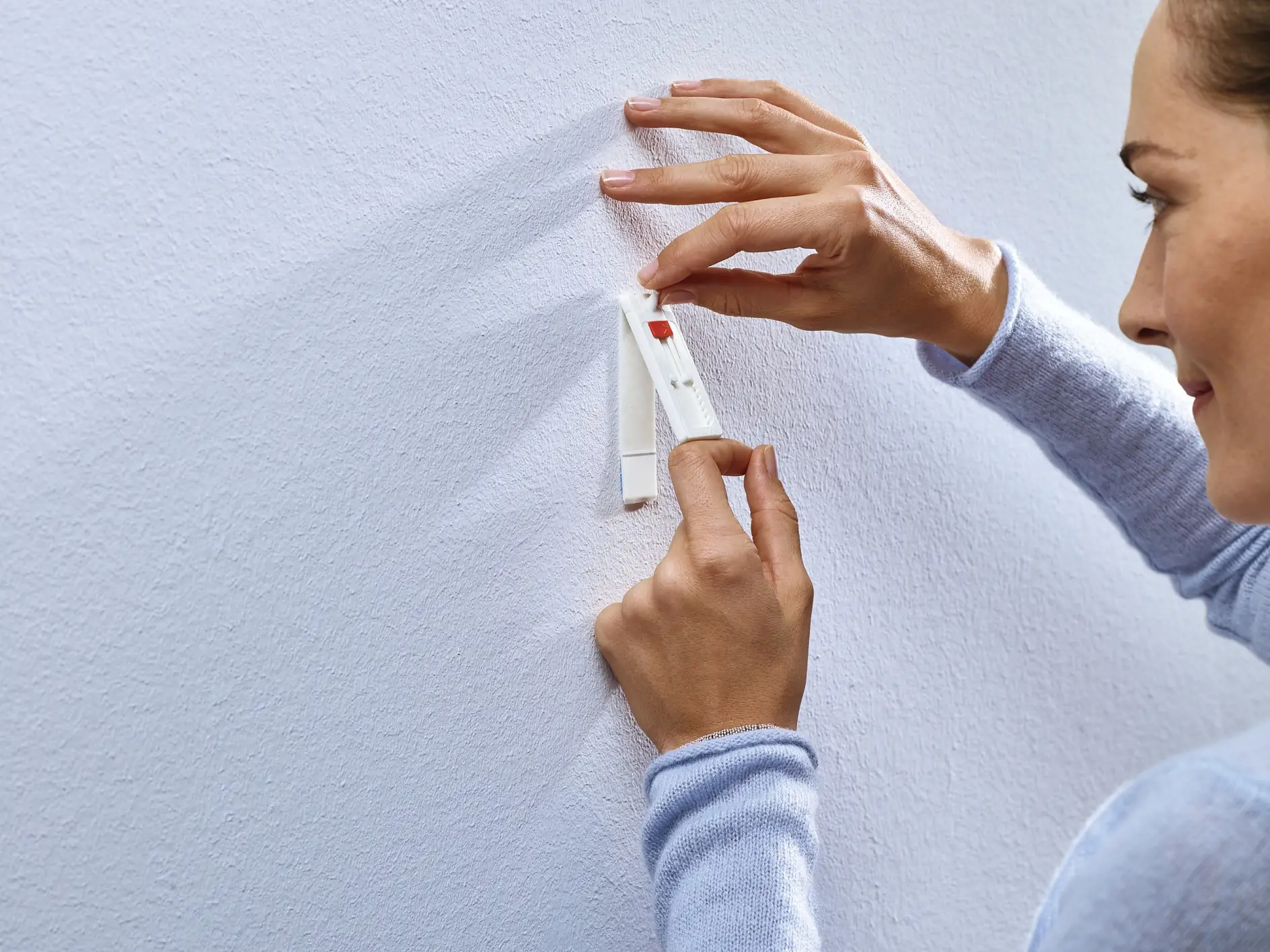 Påfør den justerbare limspiker på veggen