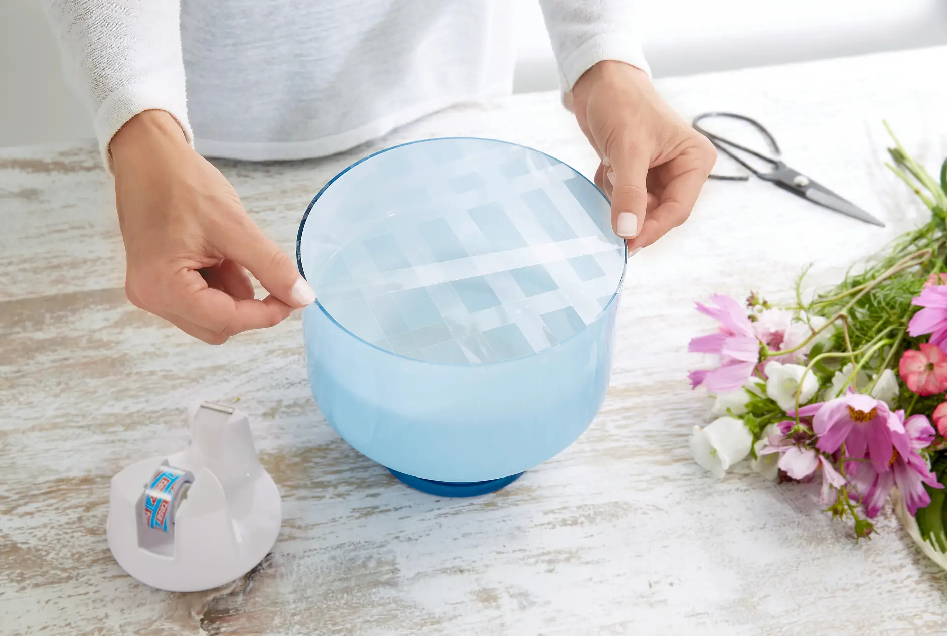 To arrange flowers in vases or bowls with wide openings, and to avoid them slipping to the side, there is a simple trick: Using tesafilm®, tape a grid on across the vase mouth, at a distance of approx. 2 cm.