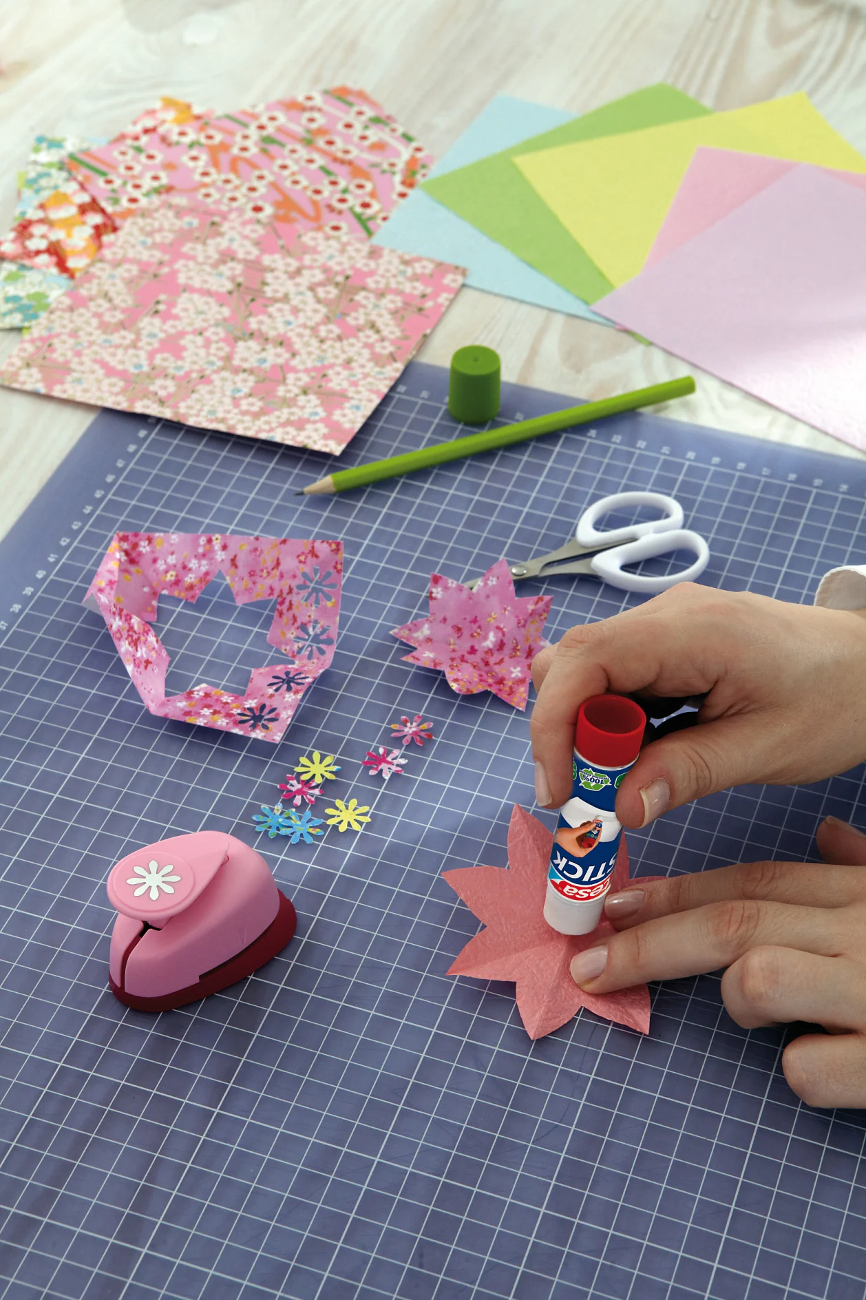 Die einfarbigen Blüten in der Mitte mit dem tesa Stick ecoLogo® bestreichen und jeweils eine gemusterte Blüte darauf kleben.