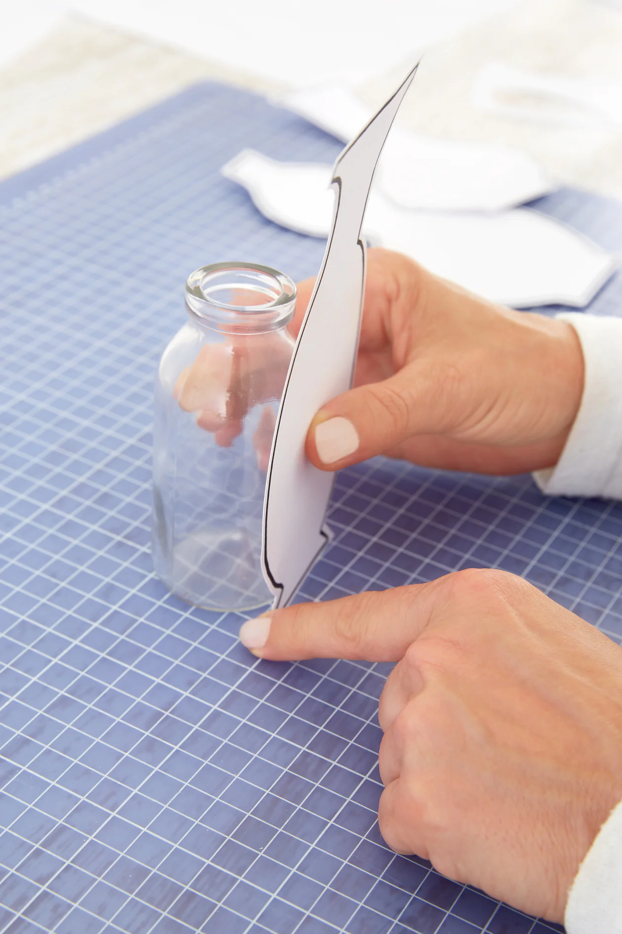 Stick the silhouettes on the glass bottles, making sure you cover them from top to bottom.