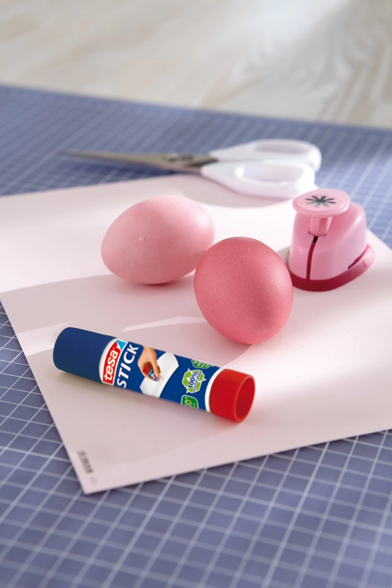 Das brauchen wir: Gefärbte Eier, Motivstanzer mit kleinem Blütenmotiv (Bastelladen), tesa Easy Stick ecoLogo®, Schere, farblich passendes festeres Papier.