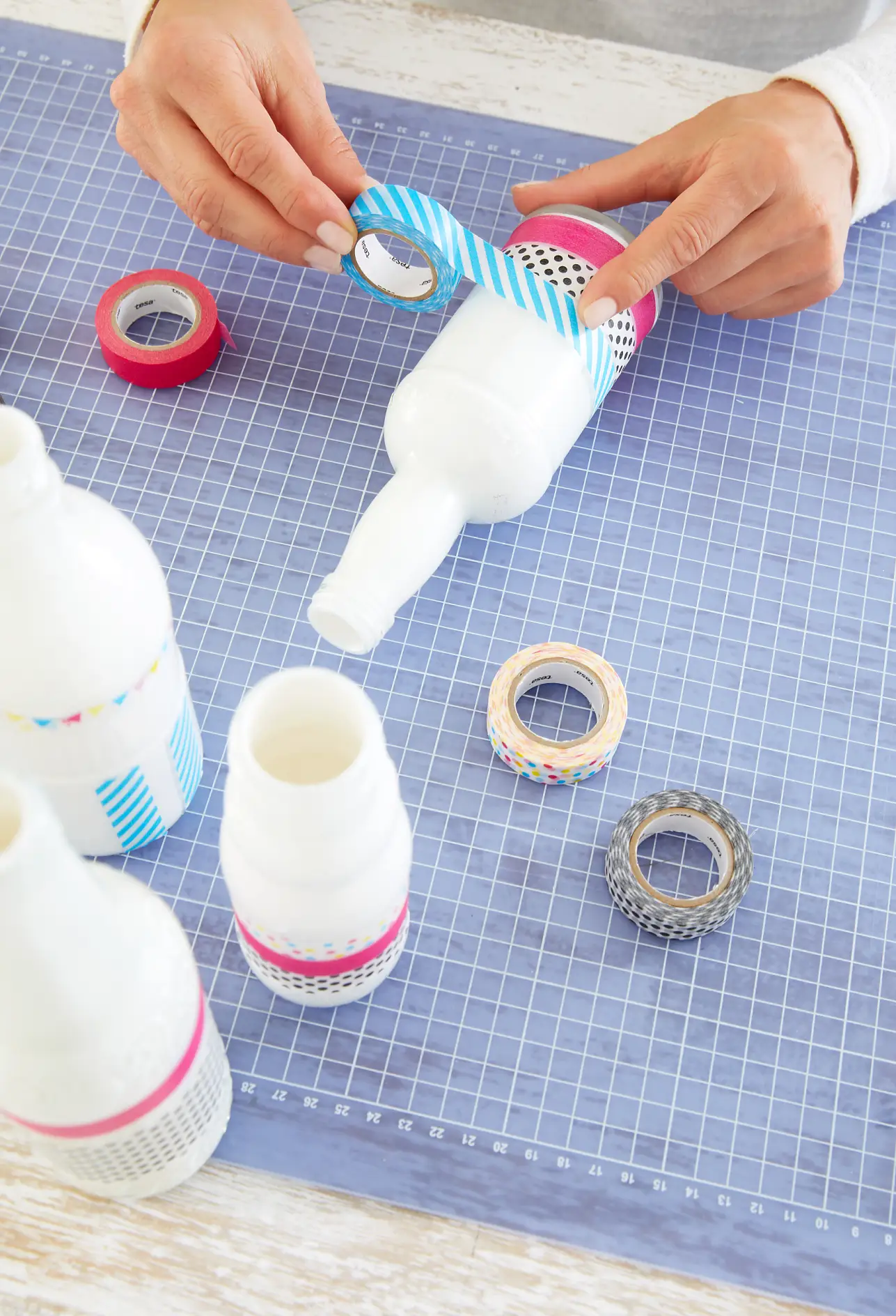 Now decorate the white bottles with tesa® Deco Tapes after your fancy.