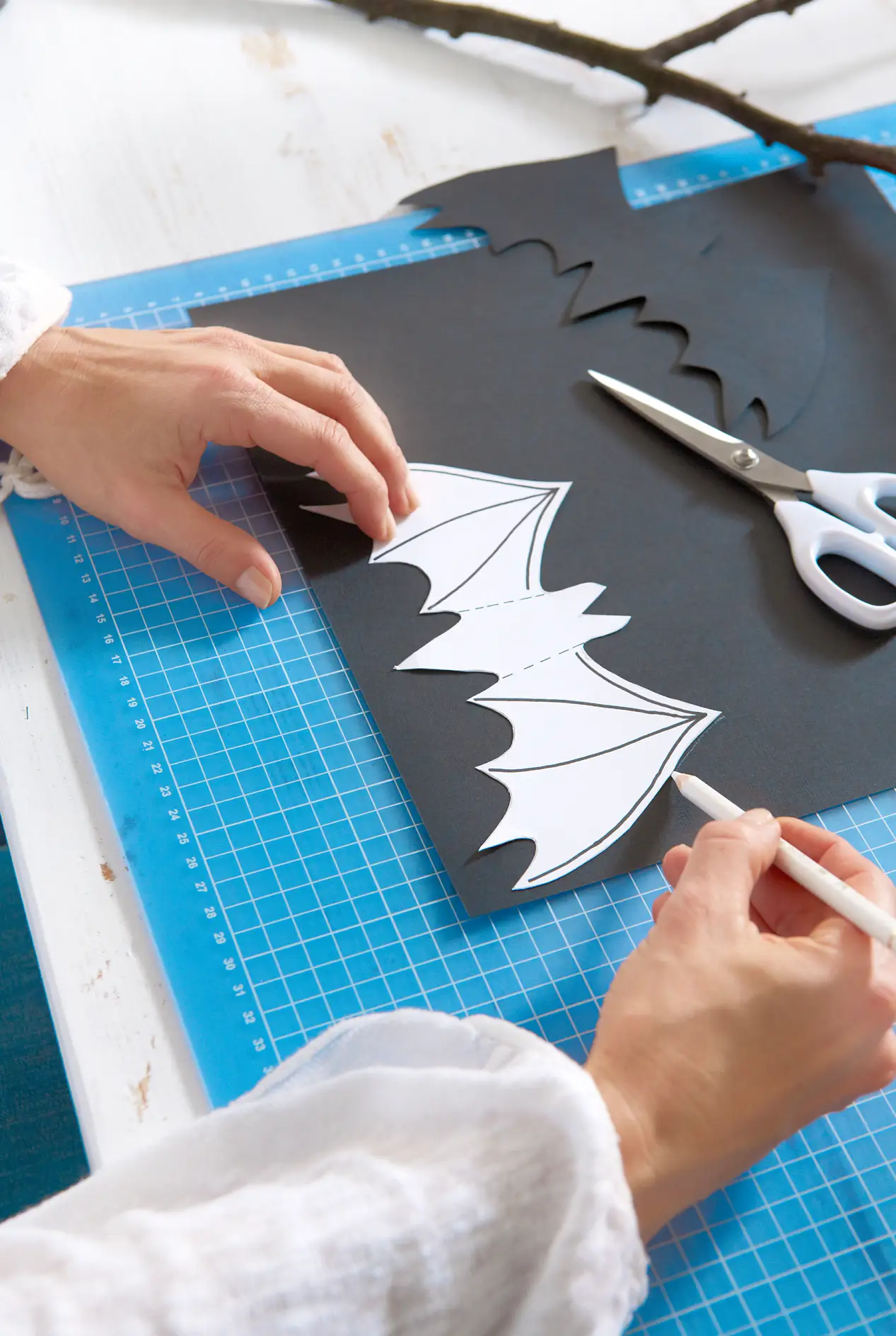 Aus dem festen Papier eine Schablone nach der Vorlage anfertigen. Die Fledermausvorlage auf die schwarze Pappe übertragen und ausschneiden.
