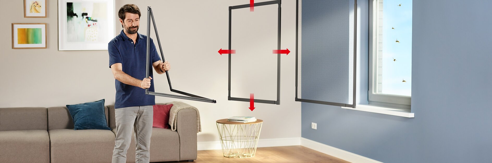 A man stands in a living room holding a window frame, demonstrating a screen installation with tesa tape. Red arrows indicate the screen fitting into the window. The room is furnished with a couch, a rug, wall art, and wooden flooring. (This text has been generated by AI)