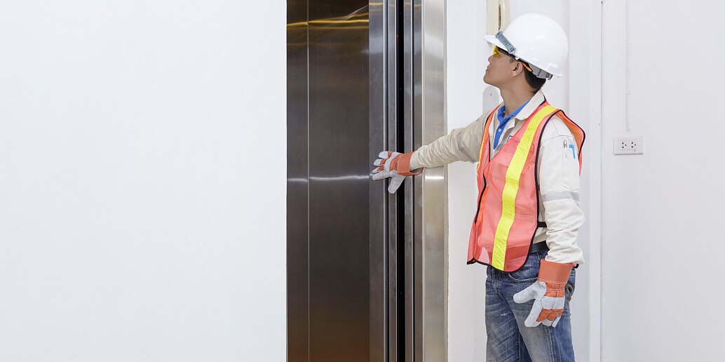 Technician investigating elevator doors Technician investigating elevator doors