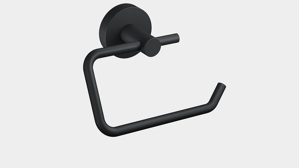 En sort mat toiletpapirholder monteret på en lysegrå væg. Holderen har et minimalistisk design med en cirkulær bund og en bøjet arm til at holde en rulle tesa-tape toiletpapir. (This text has been generated by AI)