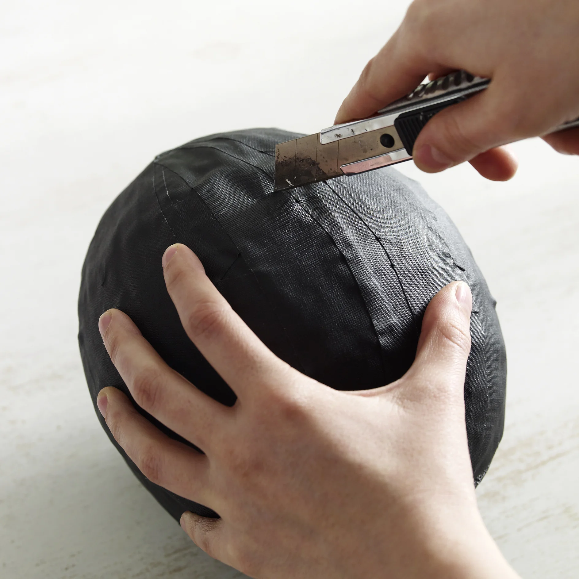 Luftballon vorsichtig mit dem Cutter halbieren.