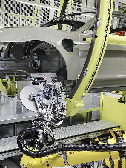 Lochverschluss an der Karosserie Die Alternative zu Kunststoff-Stopfen: Klebepads von tesa, die ein Roboter schnell und zuverlässig positioniert. (© Porsche AG / tesa SE)