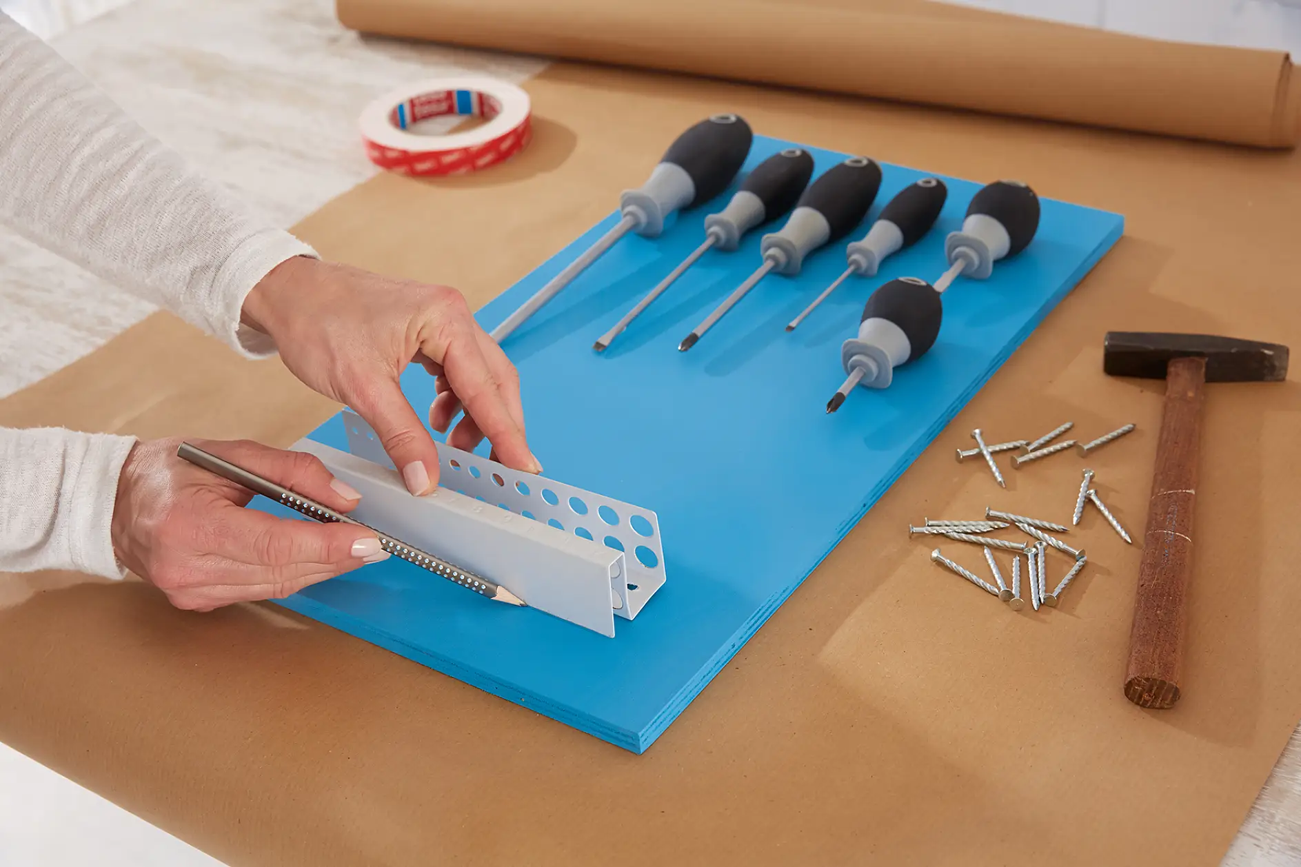 Werkzeuge und Halter auf die Platten legen und Hängepositionen zart mit Bleistift markieren.
