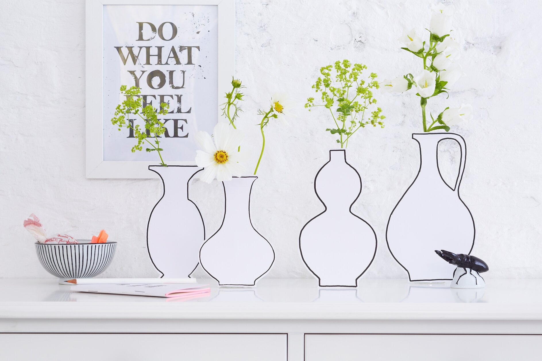 tesa trendpapier 18 / Idee 6: Papp-Silhouetten / Aufmacher Ungewöhnlichere Vasen gibt es kaum – und sie sind ganz fix nachzumachen: Hinter den Kartonattrappen verstecken sich Glasflaschen für die Blumen.