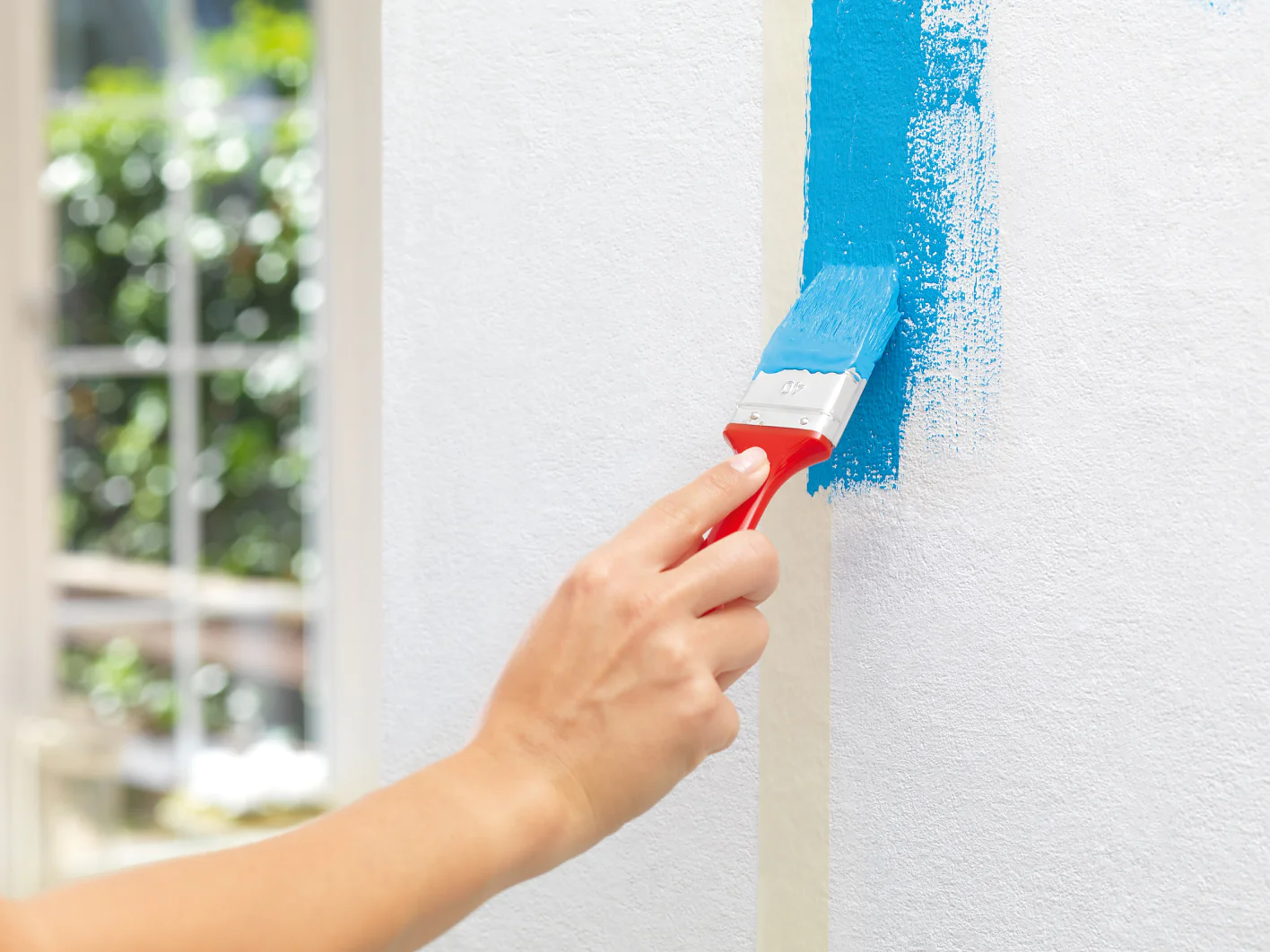 3. Arbeiten Sie sich Stück für Stück vor: Erst die Ränder mit dem Pinsel streichen, sodass die Farbe ein wenig übe das Malerband reicht.