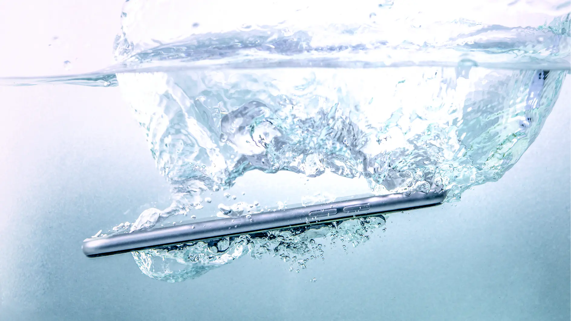 A smartphone submerged in water, creating bubbles and ripples in the surrounding liquid, is secured with tesa tape.