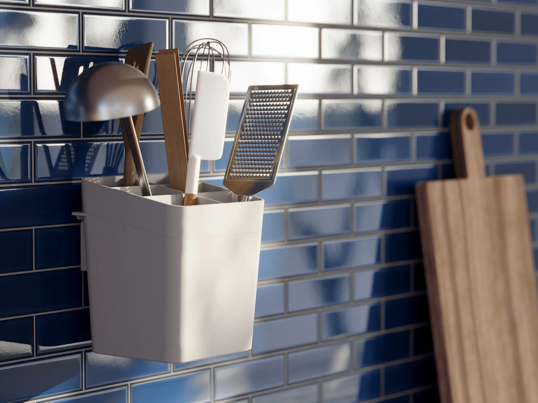A utensil holder with kitchen tools, including a ladle, whisk, and grater, is mounted on a glossy blue tiled wall using tesa tape. A wooden cutting board is leaning against the wall in the background, with sunlight streaming through a nearby window. (This text has been generated by AI)