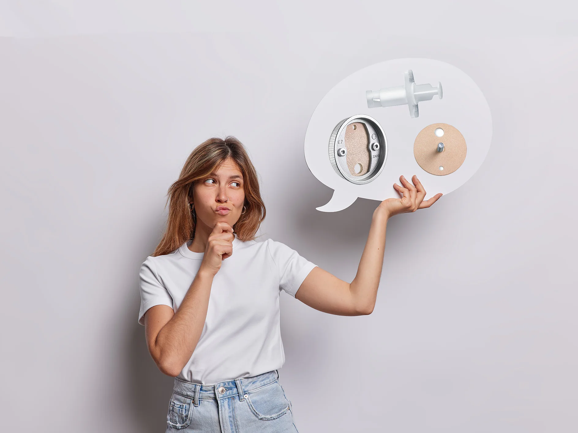A woman in a white t-shirt and jeans holds a large white speech bubble. Inside the bubble are images of a door lock mechanism and a knob, along with references to using tesa tape for installation. She has a thoughtful expression and stands against a plain white background. (This text has been generated by AI)