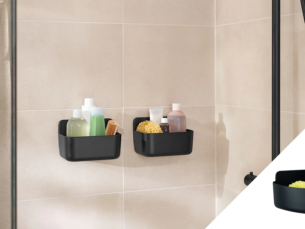 Two black wall-mounted shower caddies are attached to a tiled wall using tesa tape. They hold various bath items like bottles, a brush, and a sponge. The inset image shows the caddies with a blue bottle and a sponge. A black shower fixture is visible. (This text has been generated by AI)