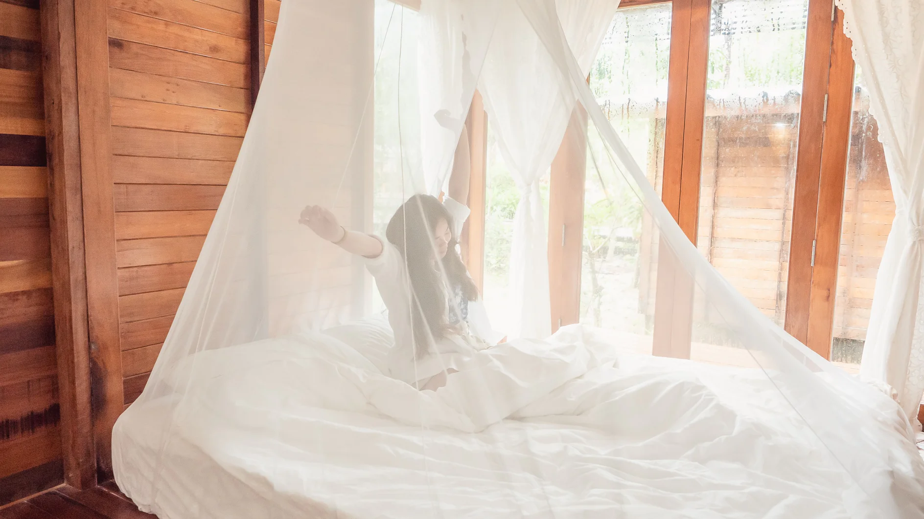 Woman stretching in bed after wake up, Happy greets new day with warm sunlight.