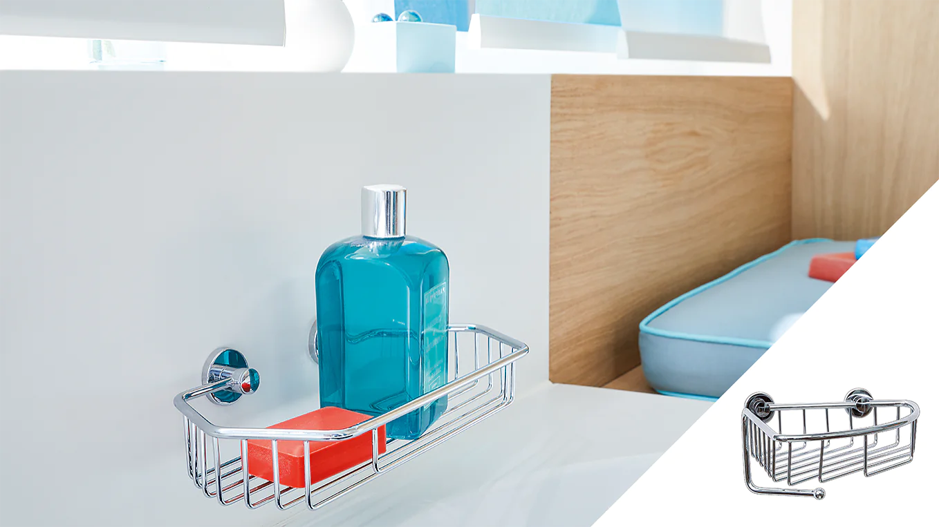 A metal shower caddy is mounted on a white wall using tesa tape. It holds a blue bottle and an orange soap bar. In the background, theres a white shelf, wooden paneling, and blue cushions. An inset image shows a close-up of the empty caddy. (This text has been generated by AI)