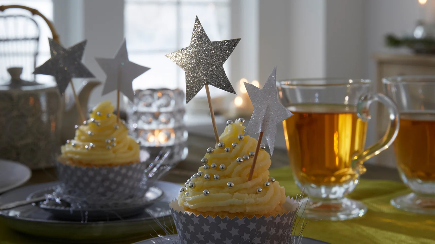 Die Cupcakes tragen ein festlich gemustertes Kleid. Passende Accessoires dazu: Deko-Sticks mit glitzernden Sternen.