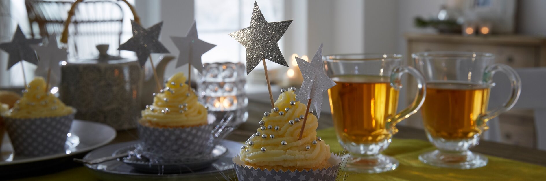 Die Cupcakes tragen ein festlich gemustertes Kleid. Passende Accessoires dazu: Deko-Sticks mit glitzernden Sternen.