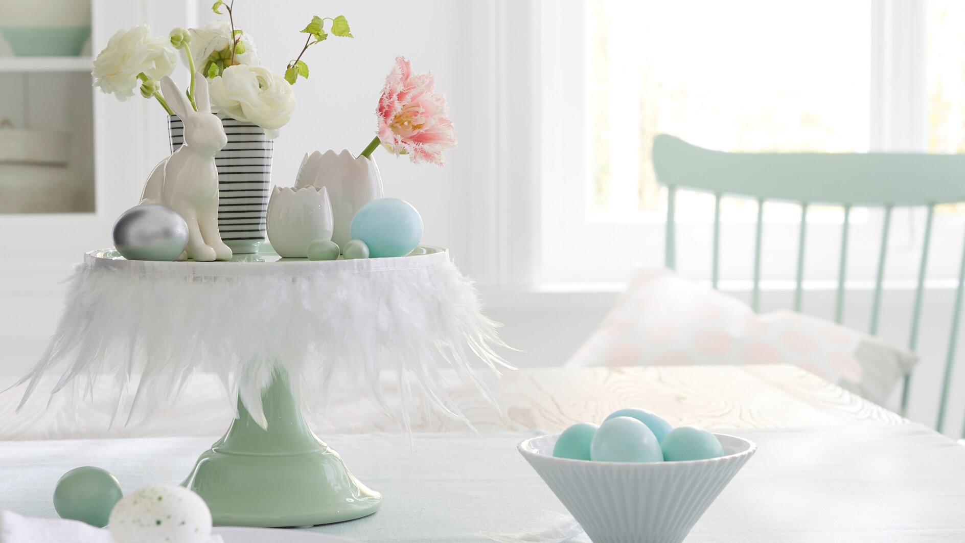 Weiße Federn machen die Etagere zur österlichen Bühne für Hasen, Blumen und Eier. Geheimwaffe für so eine schnelle Deko-Idee: tesa® Doppelseitiges Klebeband.
