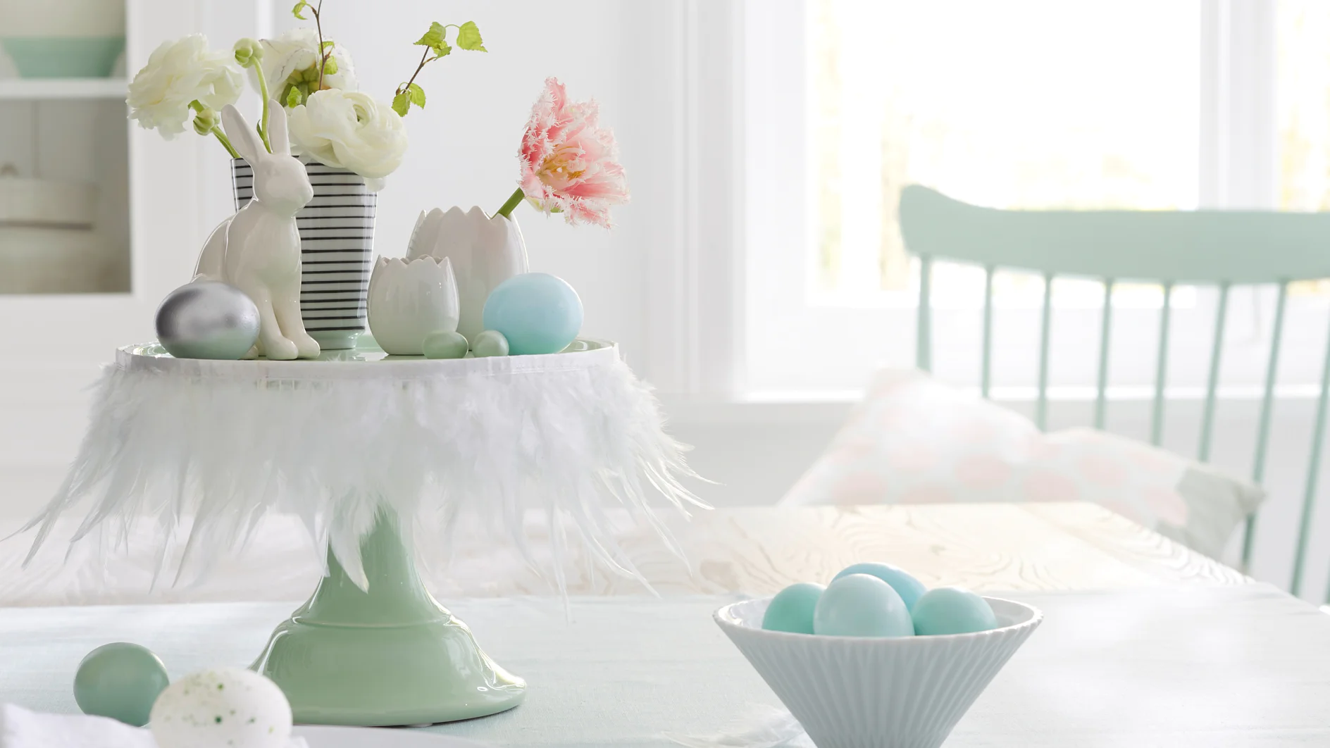 Weiße Federn machen die Etagere zur österlichen Bühne für Hasen, Blumen und Eier. Geheimwaffe für so eine schnelle Deko-Idee: tesa® Doppelseitiges Klebeband.