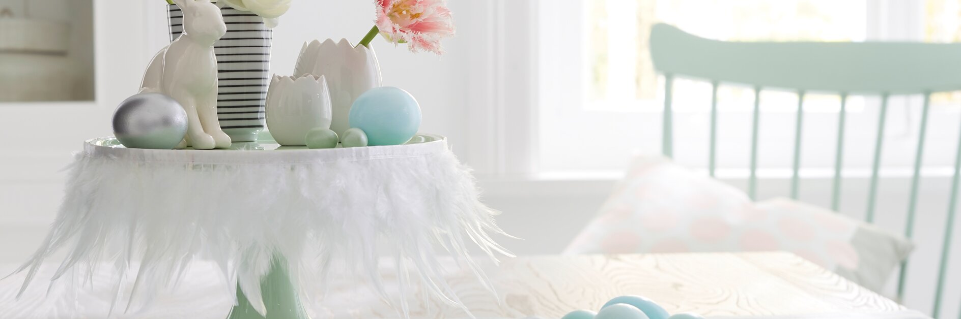 Weiße Federn machen die Etagere zur österlichen Bühne für Hasen, Blumen und Eier. Geheimwaffe für so eine schnelle Deko-Idee: tesa® Doppelseitiges Klebeband.