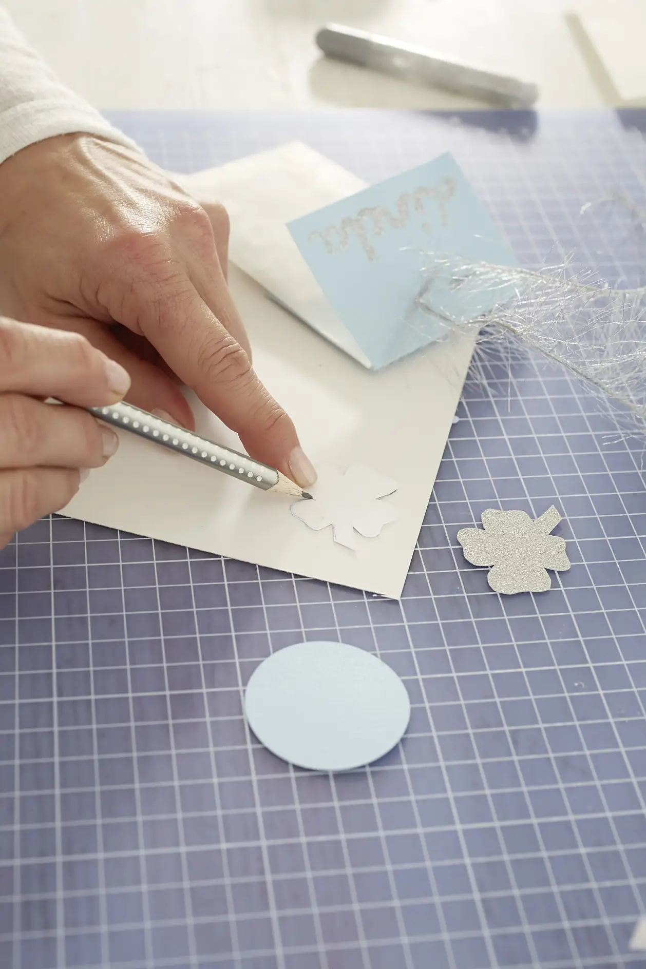 Glückskleevorlage auf das Glitzerpapier übertragen, Klee ausschneiden.