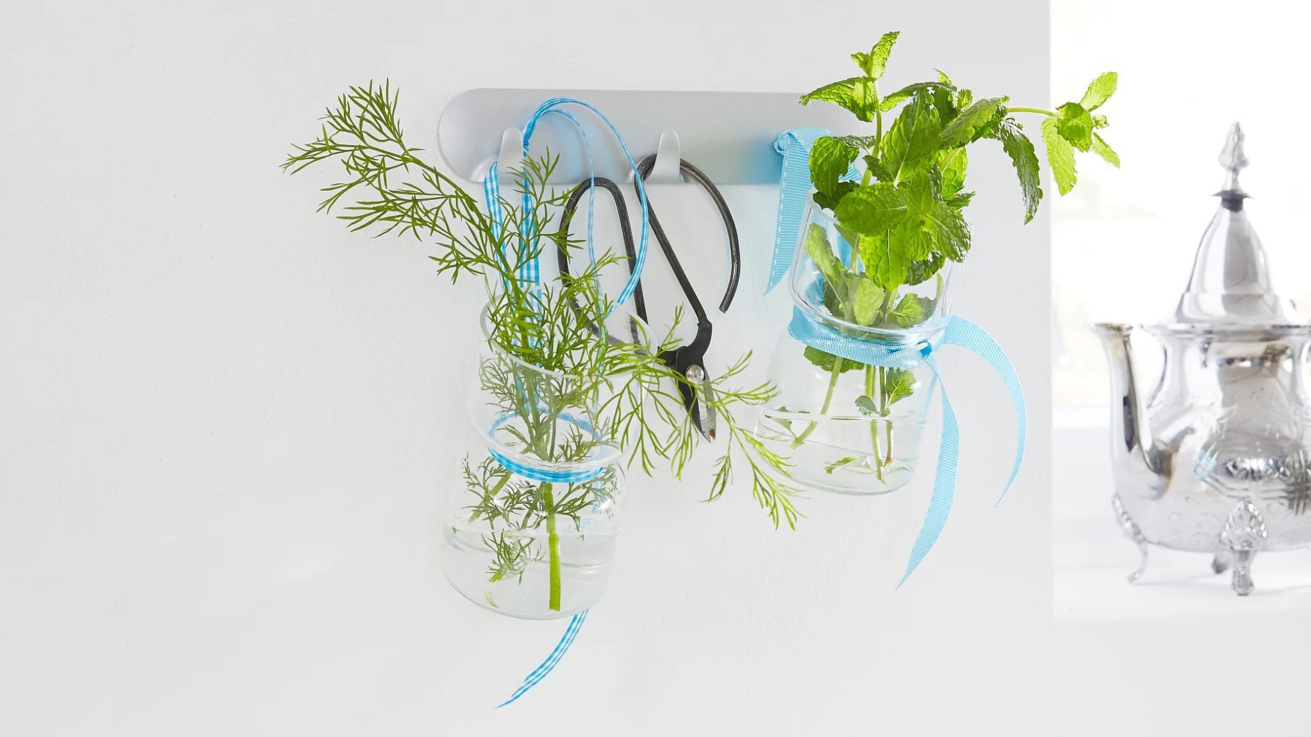 Lovely kitchen accessories: culinary herbs in glass jars - a practical kitchen decor. With the tesa Powerstrips® Hook Rack, it is easy to mount this unique kitchen storage.