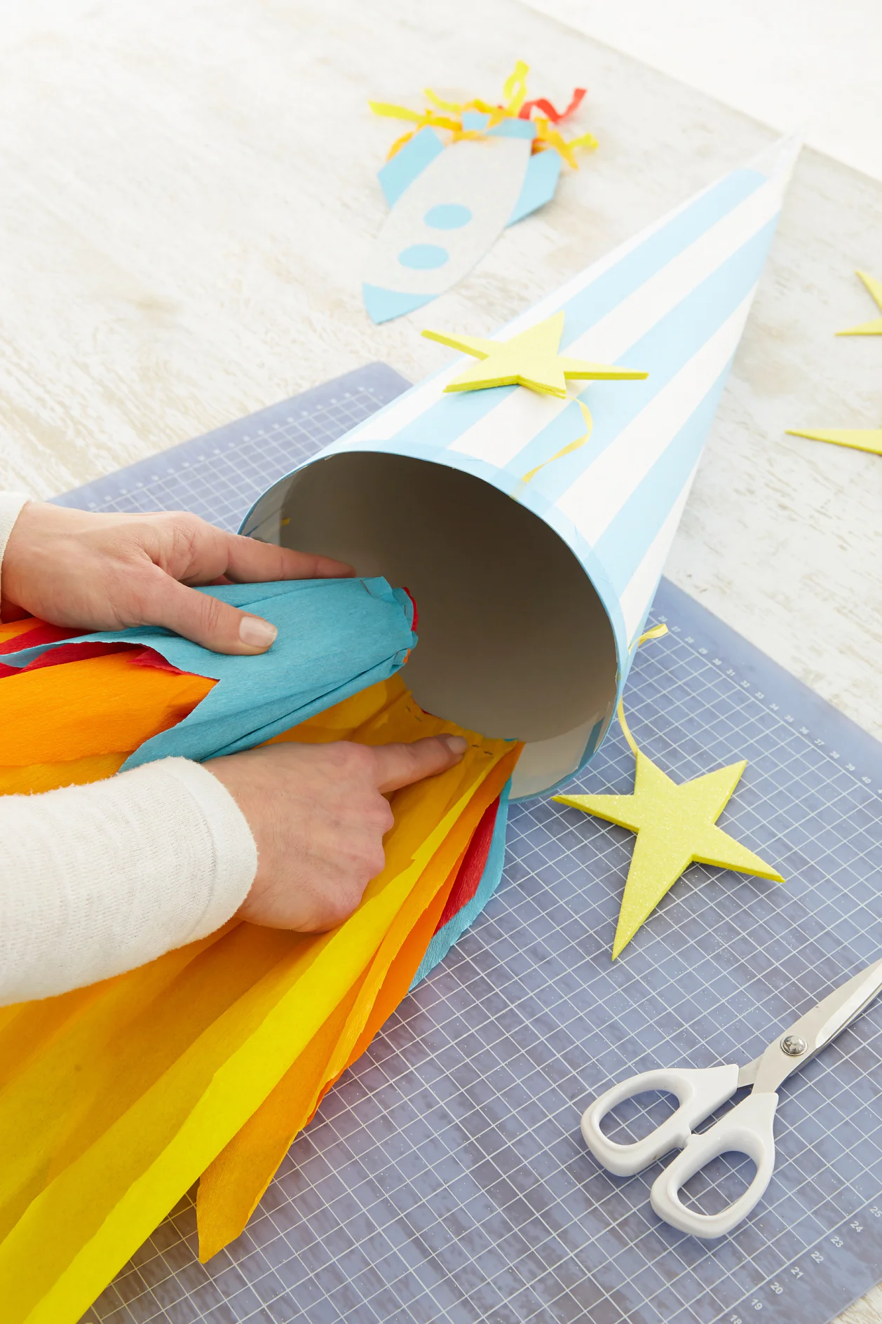 Die Krepppapierbordüre aufrollen und von innen in die Schultüte kleben.