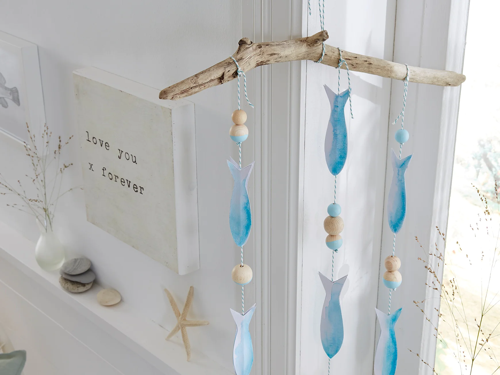 Einfach mal hängen lassen, das selbst gemachte maritime Mobile mit Papierfischen und Holzkugeln. Möglich macht's ein unauffälliger, weil transparenter tesa Powerstrips® Deco-Haken, der nach Benutzung wieder spurlos verschwinden kann.