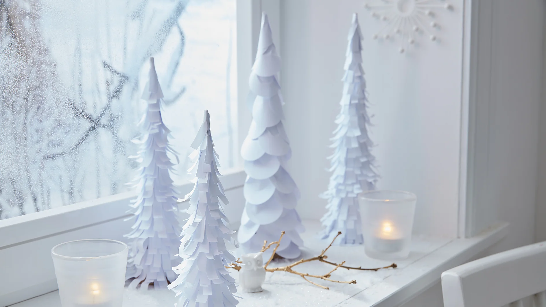 Die weißen Bäume bringen Winterstimmung ins Haus, auch wenn es draußen gar nicht schneit.