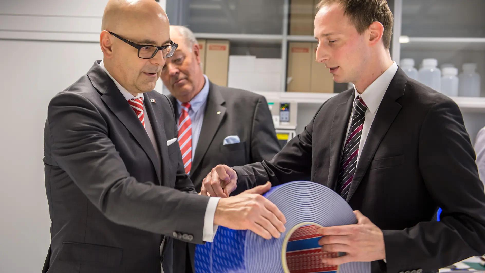 Laborleiter Dr. Tobias Blömker (r.) demonstriert Ministerpräsident Torsten Albig ein innovatives Schaumstoff-Klebeband, das für die Befestigung von Fassaden-Elementen eingesetzt werden kann. Rund drei Viertel seines Umsatzes erwirtschaftet der internationale Technologie-Konzern mit Produkten für unterschiedliche Industriebranchen.