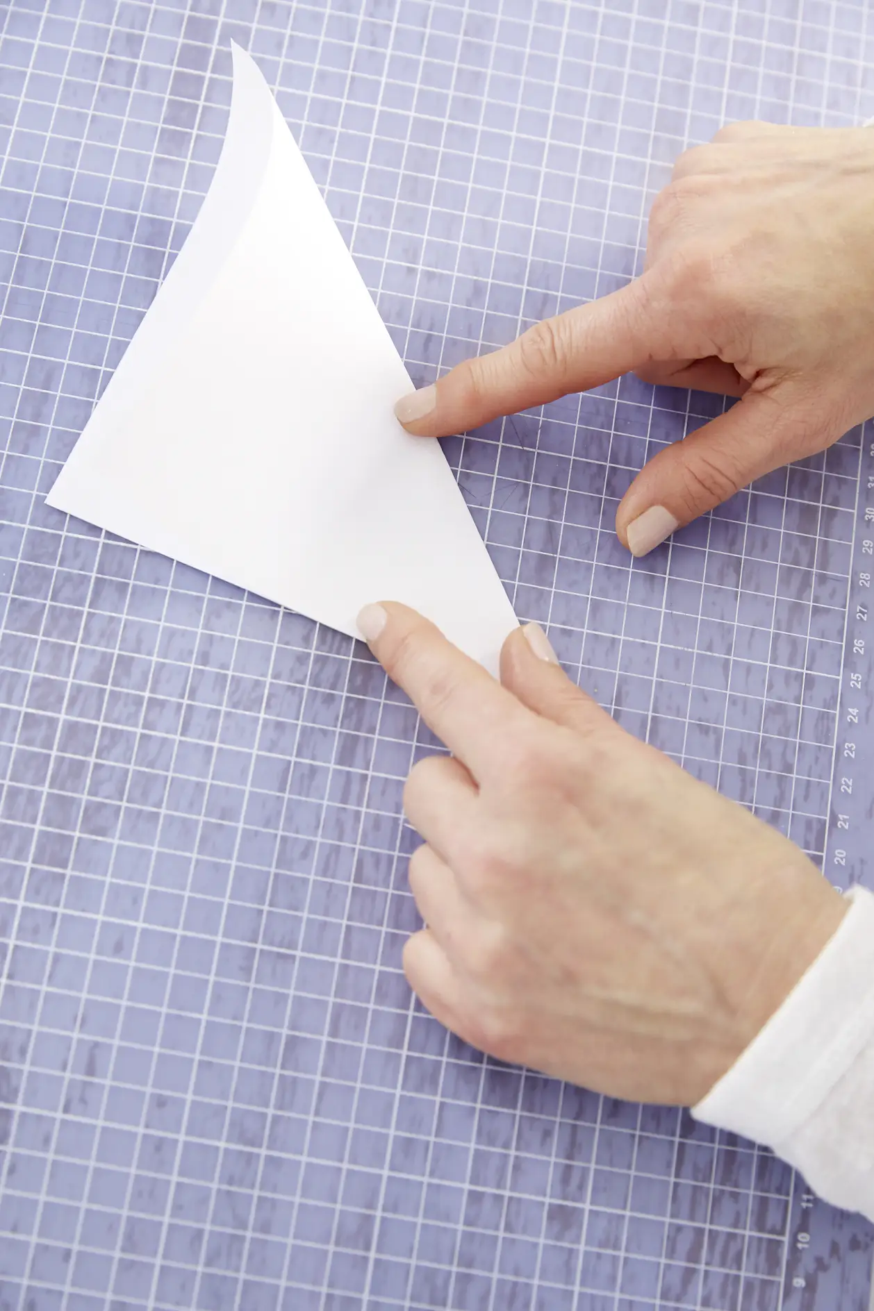 Ein quadratisches Papier diagonal falten.