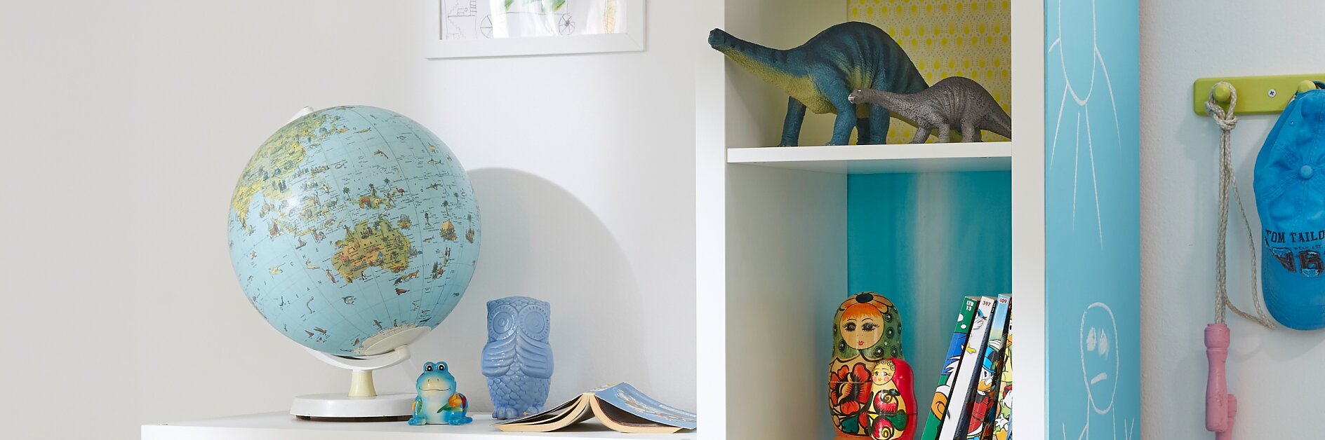 Die große, mit Powerbond® verklebte Tafel an der Seite lädt zu Schreib- oder Malversuchen ein, und jedes Regalfach hat seinen eigenen bunt gemusterten Hintergrund – wenn das kein tolles Kindermöbel ist!