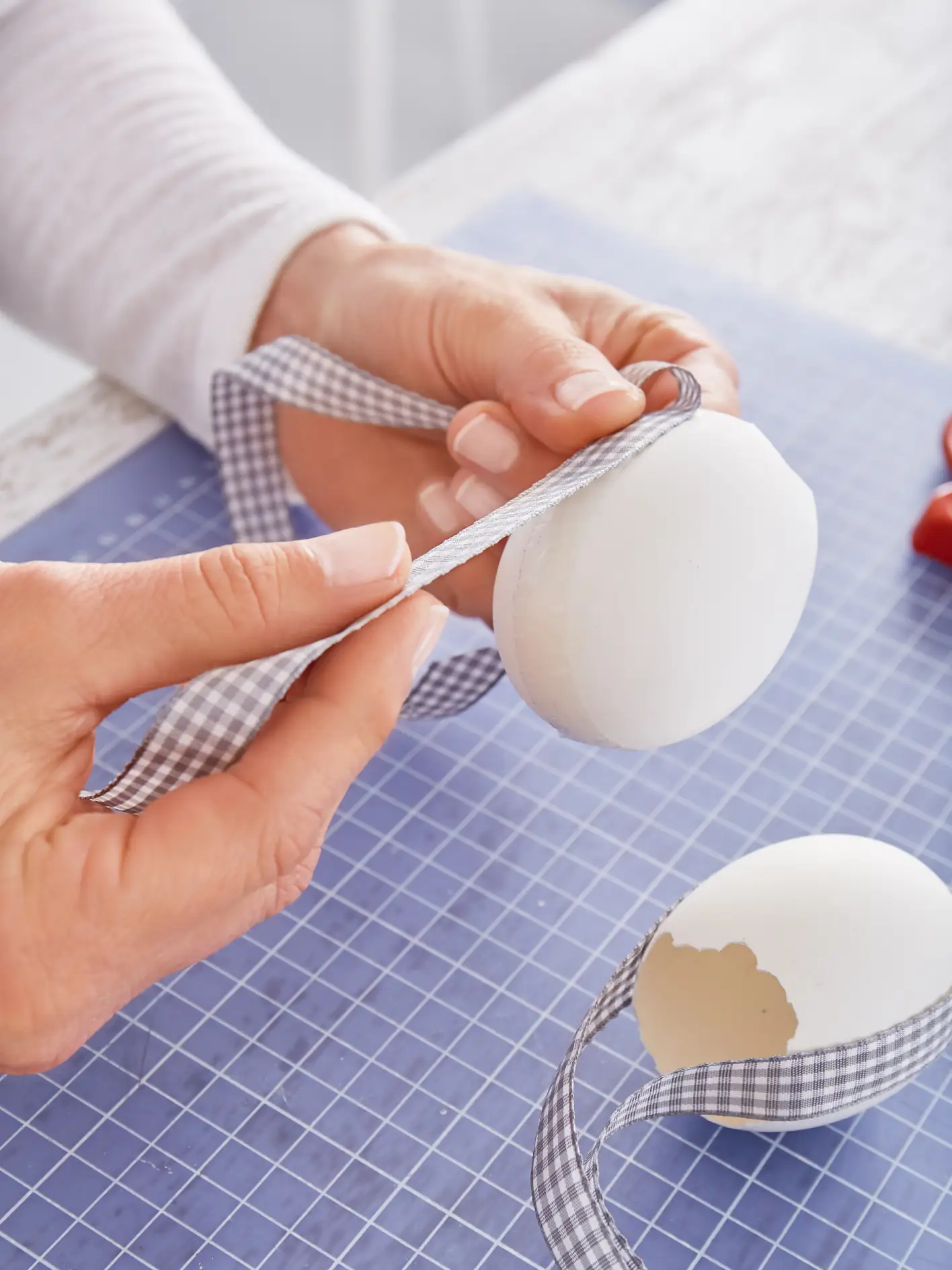 Das Ei am Ast befestigen, mit etwas Wasser füllen und kleine Blümchen hineinstellen.