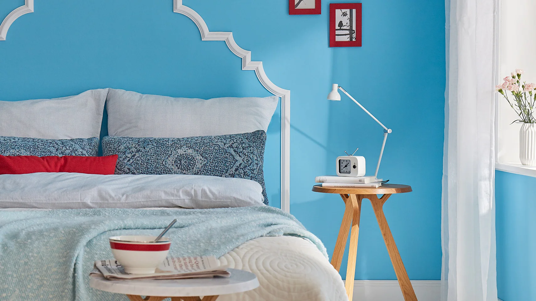 Dieses Betthaupt ist ein schöner Blender: Es besteht nämlich nur aus Stuckleisten, die mithilfe von Montagekleber sicher auf der Wand an der Stirnseite des Bettes haften. Große (echte) Kissen machen das Bett gemütlich.