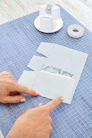 Alle Linien werden von einer Seite aus gefaltet. Dafür das Papier mit der Vorderseite nach unten legen und alle Längslinien nach innen falten.