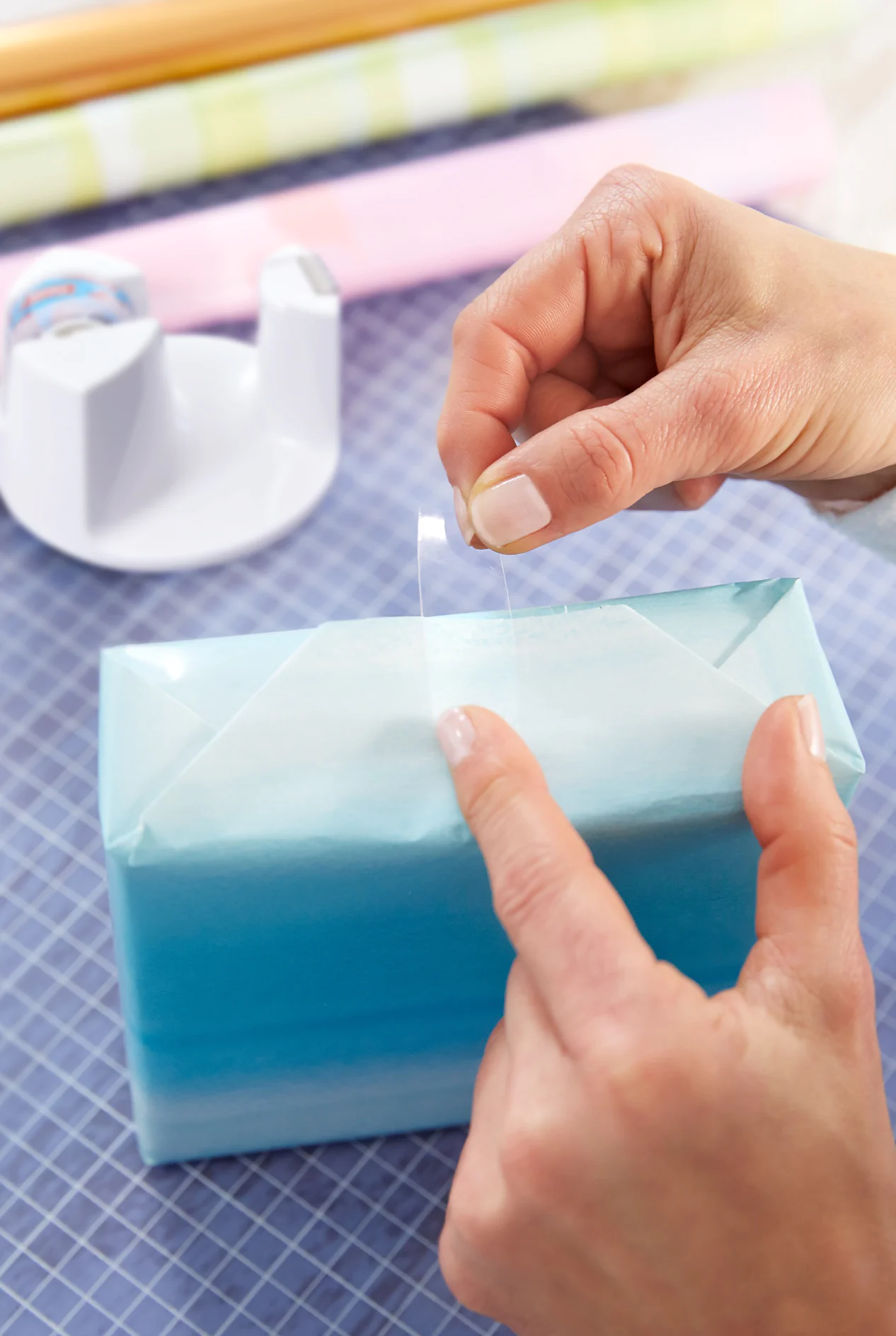 Geschenke einpacken. Papier mit tesafilm® fixieren.