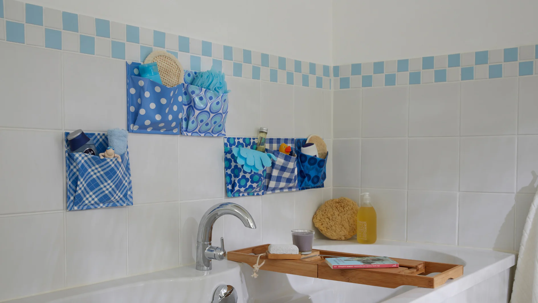 Mit dem Taschenspielertrick ist das Badezimmer immer hübsch aufgeräumt: Einfach aus wasserfestem Wachstuch Utensilos nähen, an die Fliesen kleben und füllen!