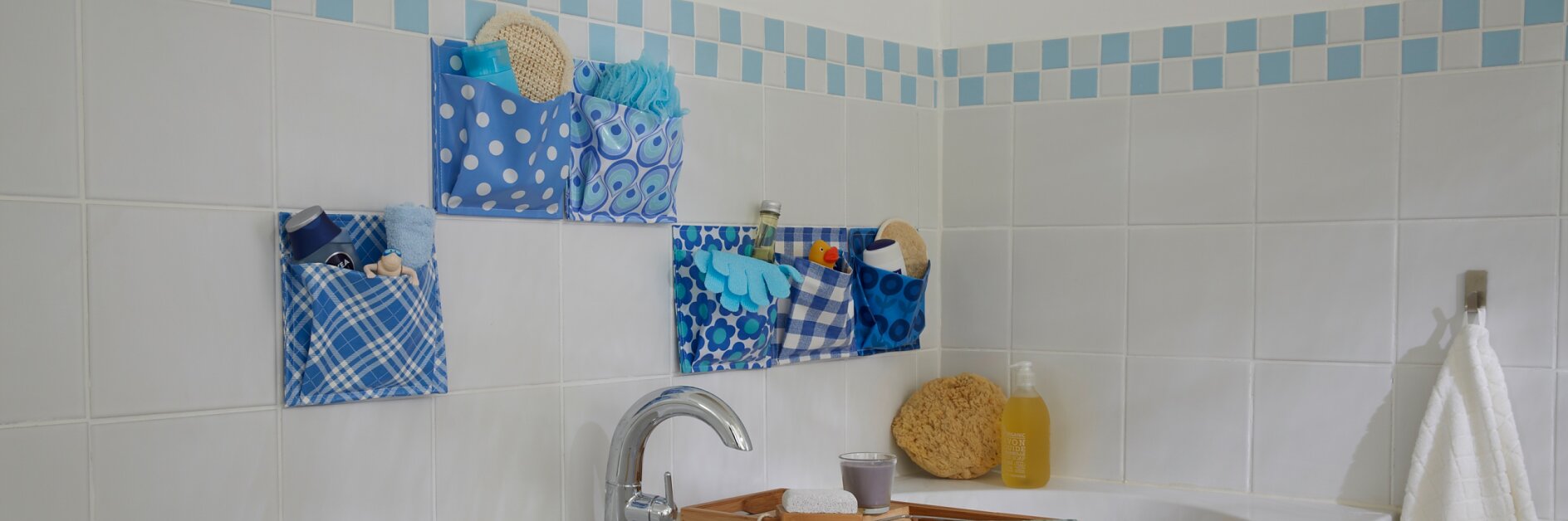Mit dem Taschenspielertrick ist das Badezimmer immer hübsch aufgeräumt: Einfach aus wasserfestem Wachstuch Utensilos nähen, an die Fliesen kleben und füllen!