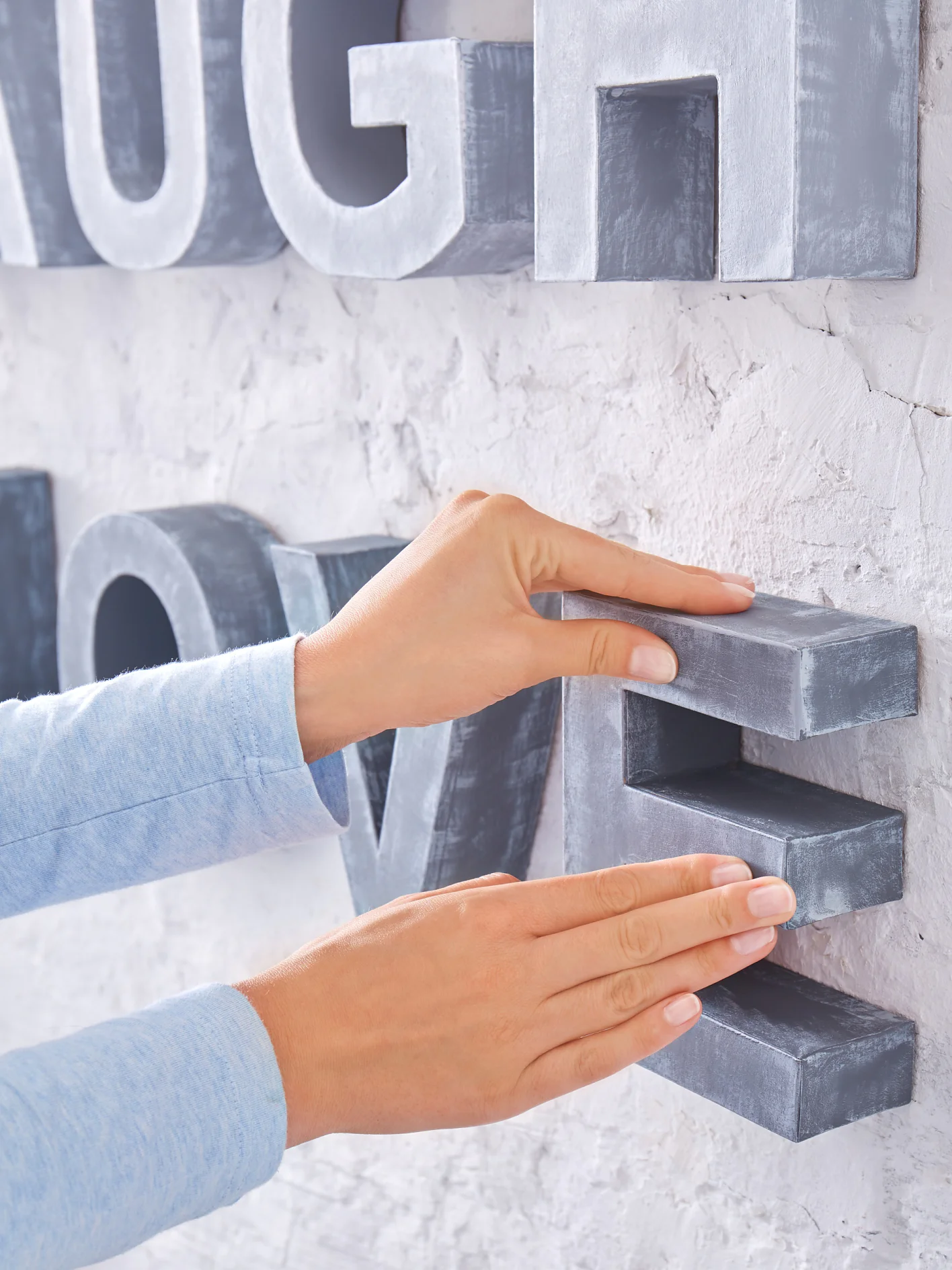 Buchstaben an gewünschter Stelle an die Wand drücken.