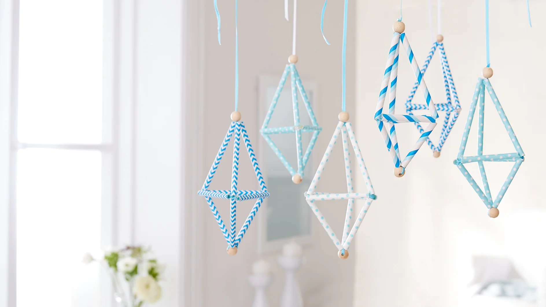 Kaum zu glauben, aber diese kleinen Flugobjekte werden aus Strohhalmen mit etwas Geschick selbst gefädelt. Also einfach mal ausprobieren und das aparte Kunstwerk dann mithilfe eines Powerstrip® Transparent DECO Hakens LARGE an der Decke befestigen.