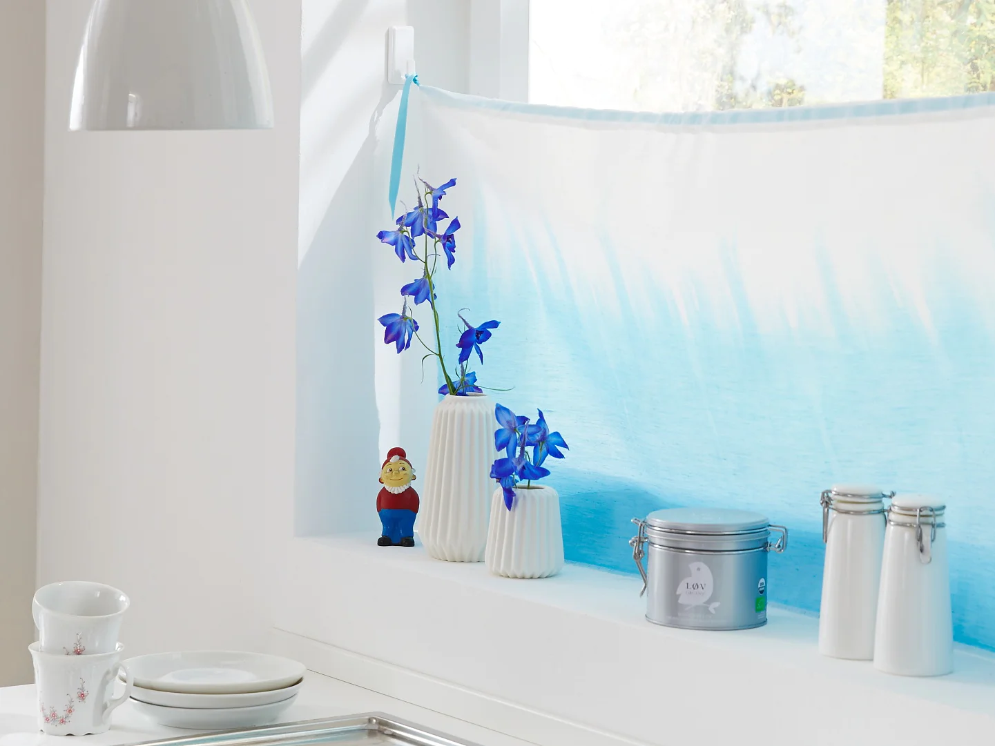 Es muss einem ja nicht jeder bei der Küchenarbeit auf die Finger schauen. Deshalb kommt eine selbst eingefärbte Scheibengardine ans Fenster. Gehalten wird sie von Powerstrips® Haken, die einfach auf die Wand geklebt werden.