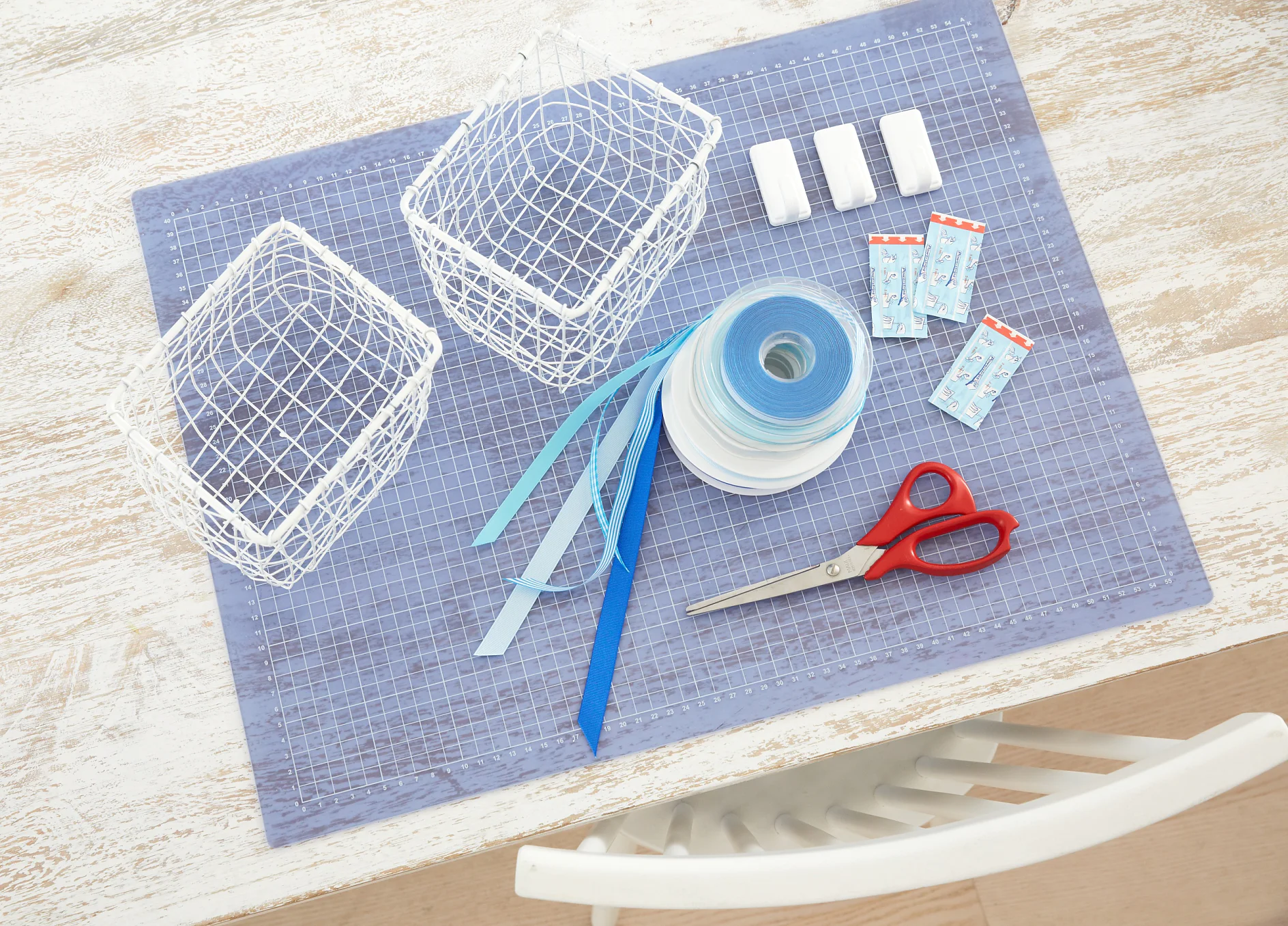 tesa trendpapier 26 / Idee 9: Metallkörbe / Schritt 1 Das brauchen wir: Kleine weiße Drahtkörbe, Bänder unterschiedlich breit und gemustert, Schere, tesa Powerstrips® Haken LARGE Classic