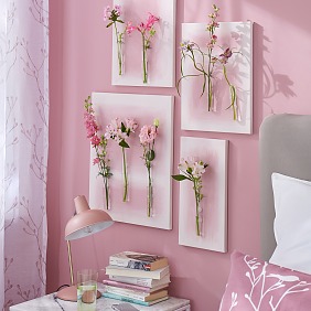 Gemalte Blumen hat jeder an der Wand hängen, aber echte? Dafür braucht man ein wenig Basteltalent, Leinwand, Reagenzgläser, das richtige Klebe-Know-how und natürlich die Hauptdarsteller: mehrere ungewöhnliche Einzelblüten! Hier in abgestuften Tönen von Weiß bis Magenta als schöne Ergänzung zu der rosaroten Umgebung.