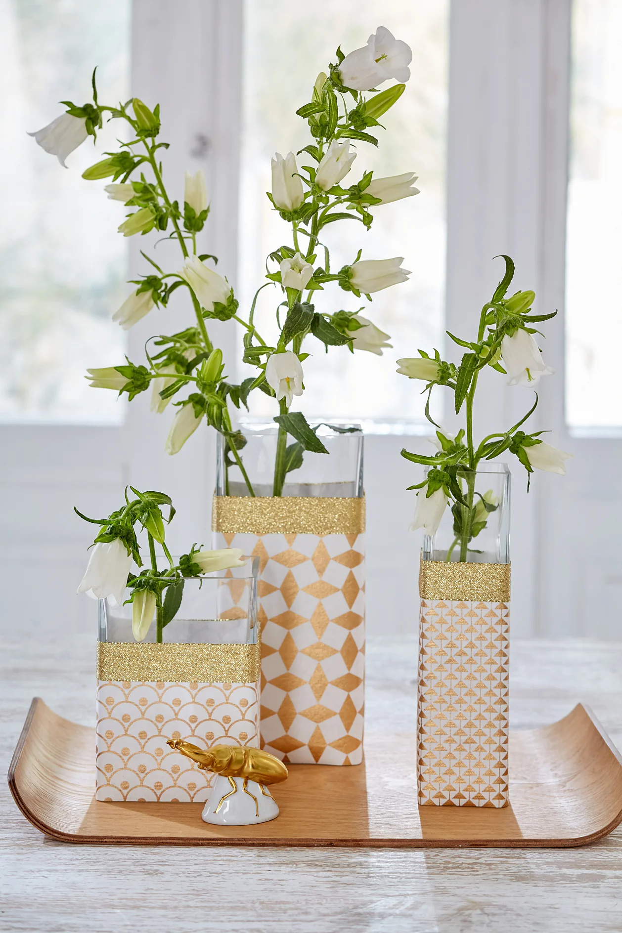 tesa trendpapier 27 / Tipps & Tricks / Flott verpackt Schlichte Glasvasen sind schön, aber manchmal auch ein bisschen langweilig. Da können Geschenkpapier und passendes -band ganz schnell Abhilfe schaffen. Einfach den Umfang der Vasen ausmessen, Papier und Band entsprechend zuschneiden, um die Vase legen und auf der Rückseite mit tesafilm® fixieren. Mal ehrlich: Einfacher geht’s doch wirklich nicht!