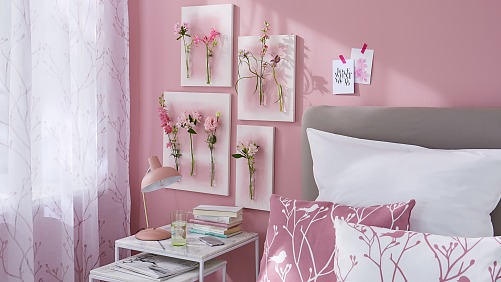 Gemalte Blumen hat jeder an der Wand hängen, aber echte? Dafür braucht man ein wenig Basteltalent, Leinwand, Reagenzgläser, das richtige Klebe-Know-how und natürlich die Hauptdarsteller: mehrere ungewöhnliche Einzelblüten! Hier in abgestuften Tönen von Weiß bis Magenta als schöne Ergänzung zu der rosaroten Umgebung.